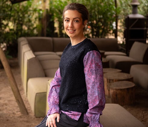 Tessuto a fantasia floreale lilla, mostrato anche su modella con gilet nero Tessuto a fantasia floreale lilla, mostrato anche su modella con gilet nero